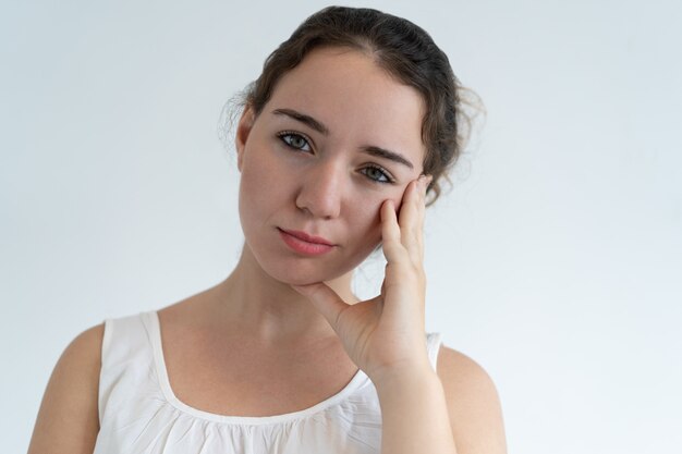 Bored lovely woman touching face