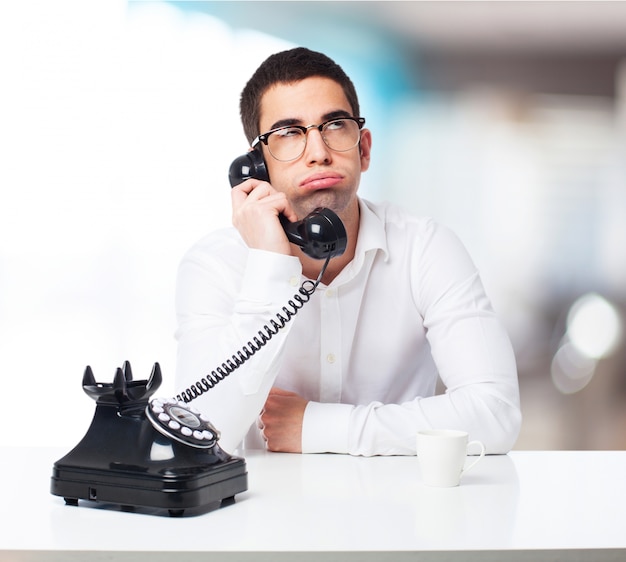 Uomo annoiato parlando di un telefono nero