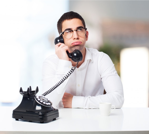 Foto gratuita uomo annoiato parlando al telefono