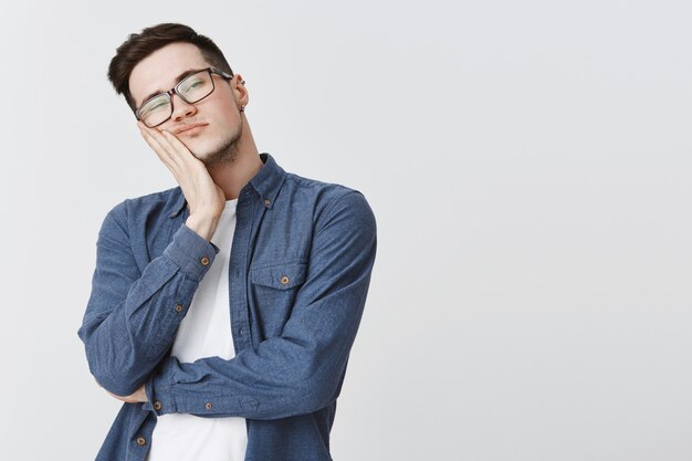 Bored student in glasses looking right reluctant, falling asleep