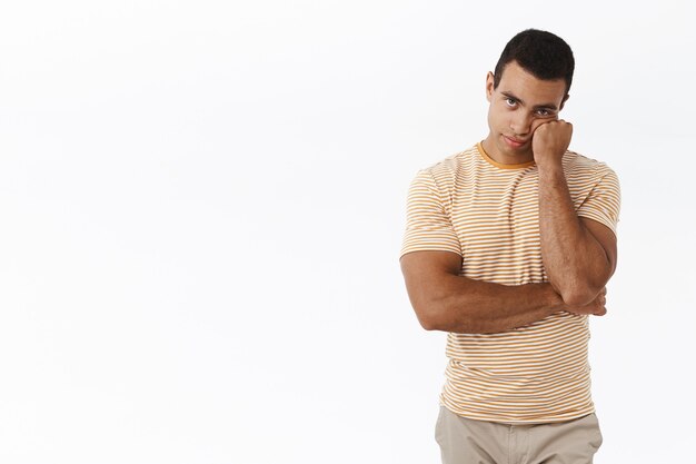 Free photo bored and unamused caucasian man standing white background reluctant