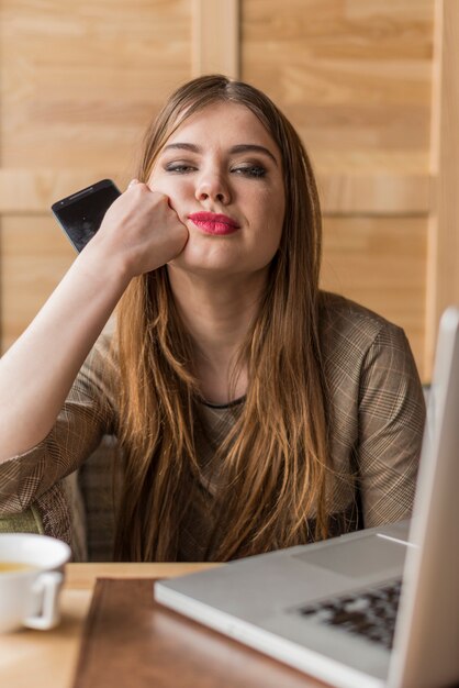 Bored woman with mobile phone in hand