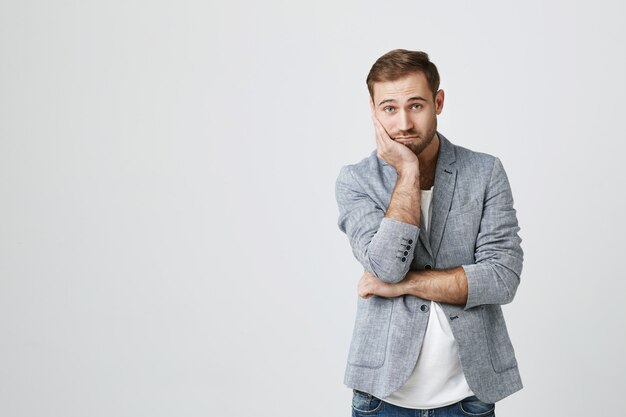 Bored young male employee looking reluctant