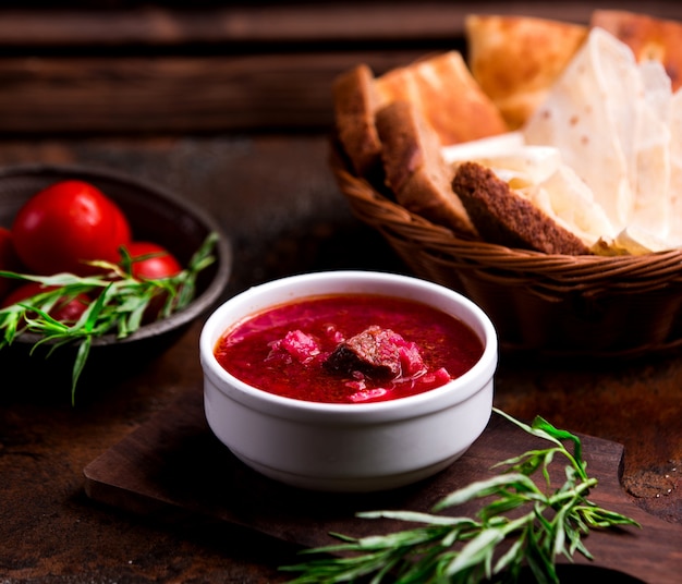 Borsch with meat in a white bowl