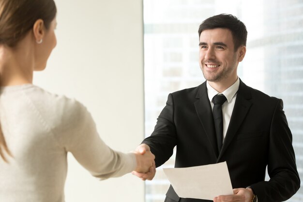 Boss congratulating female employee with promotion