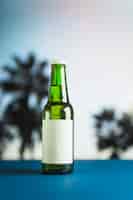Foto gratuita bottiglia di birra sul tavolo blu