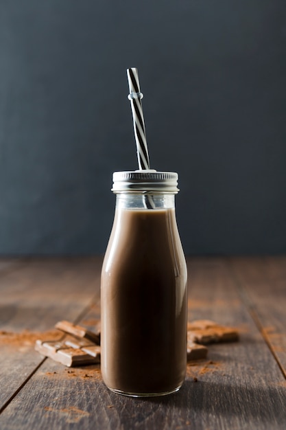 Foto gratuita bottiglia di frappè al cioccolato con cannuccia