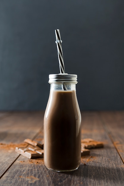 Bottle of chocolate milkshake with straw