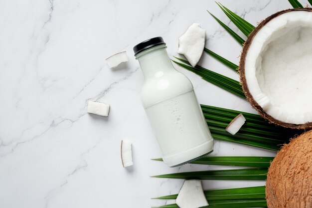 bottle of coconut milk put on white marble background