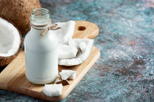 bottle of coconut milk put on wooden cutting board