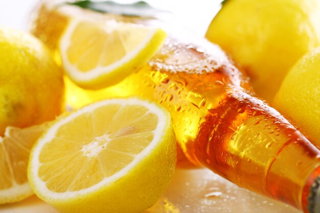 Foto gratuita bottiglia di birra fredda con limoni freschi