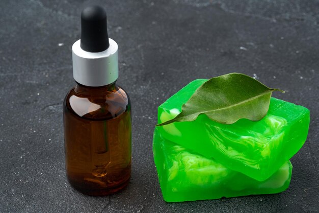 Bottle of eucalyptus essential oil and soap bars on black background