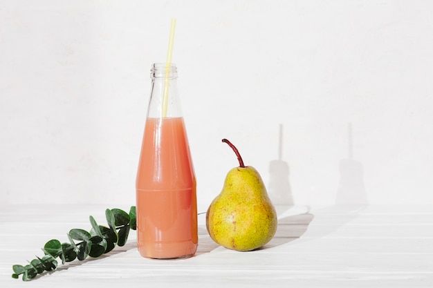 Bottle of juice with pear and leaves