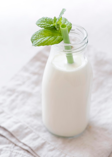Bottle of milk and peppermint leaves high view