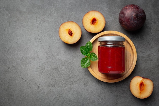 Free photo bottle of plum jam  put on dark floor