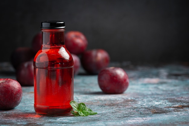 Free photo bottle of plum put on gray floor