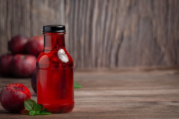 bottle of plum put on wooden floor