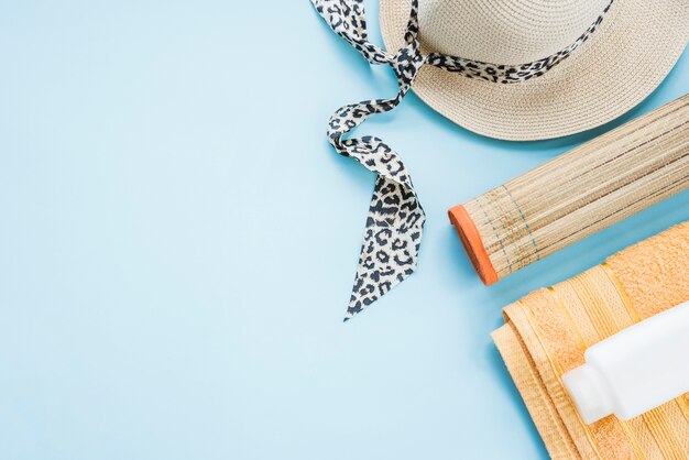 Bottle on towel near mat and hat