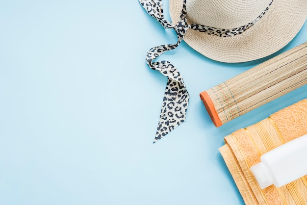 Bottle on towel near mat and hat