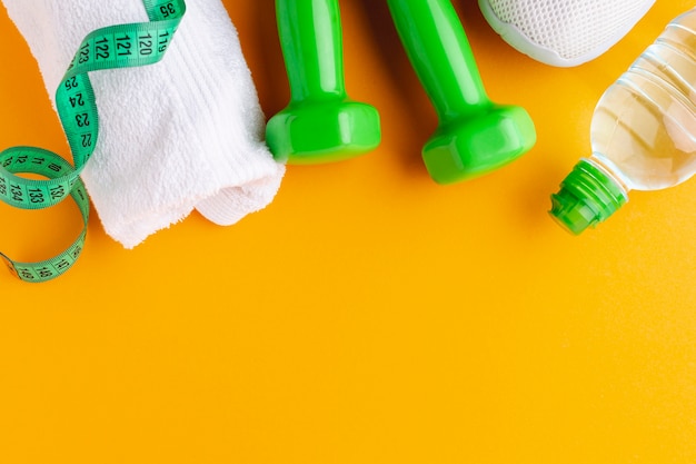 Bottle of water towel and weights with copy space