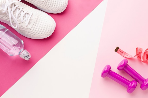 Bottle of water weights and white sneakers