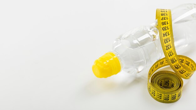 Bottle of water and yellow centimetre copy space