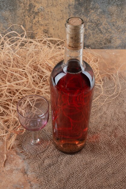 Bottle of wine with wineglass on burlap