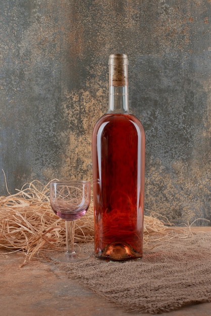 Foto gratuita bottiglia di vino con bicchiere di vino su tela.