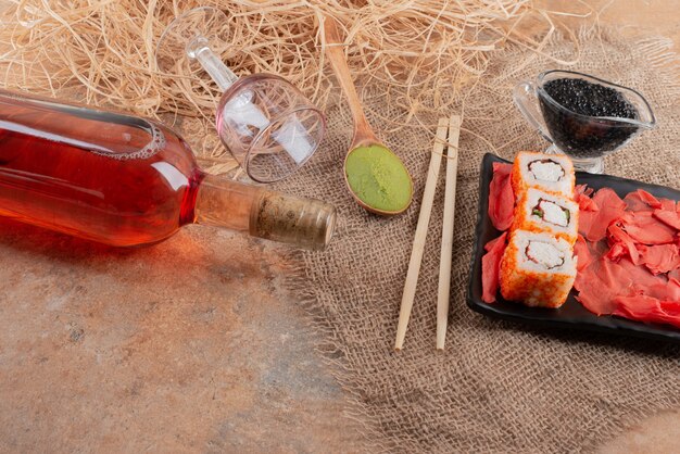 Bottle of wine with wineglass and sushi on burlap