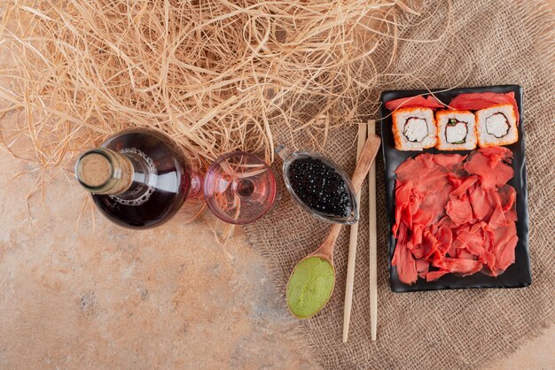 Bottle of wine with wineglass and sushi on burlap