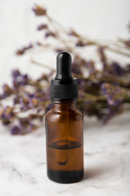 Bottle with pipette next to lavender bouquet