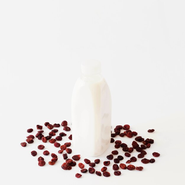 Bottle with white liquid between dried fruits