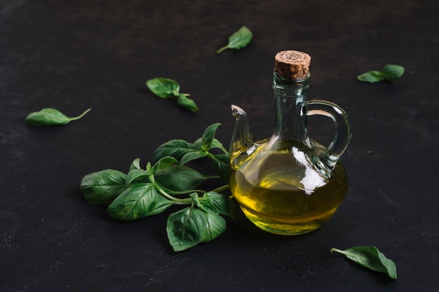 Foto gratuita olio d'oliva in bottiglia con spinaci attorno