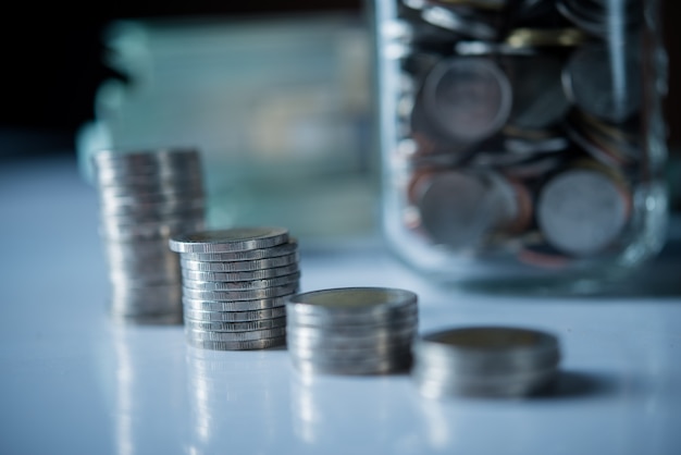 Bottles of cash with coins  in saving money concept