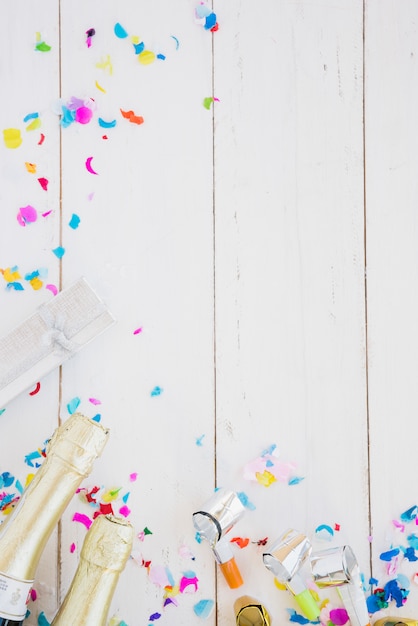 Bottles of drink near present box between confetti