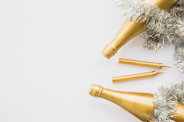 Bottles of drink near tinsel and firework sparklers 