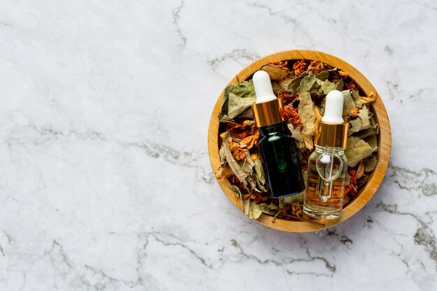 Free photo bottles of herbal spa treatment oil put in wooden bowl