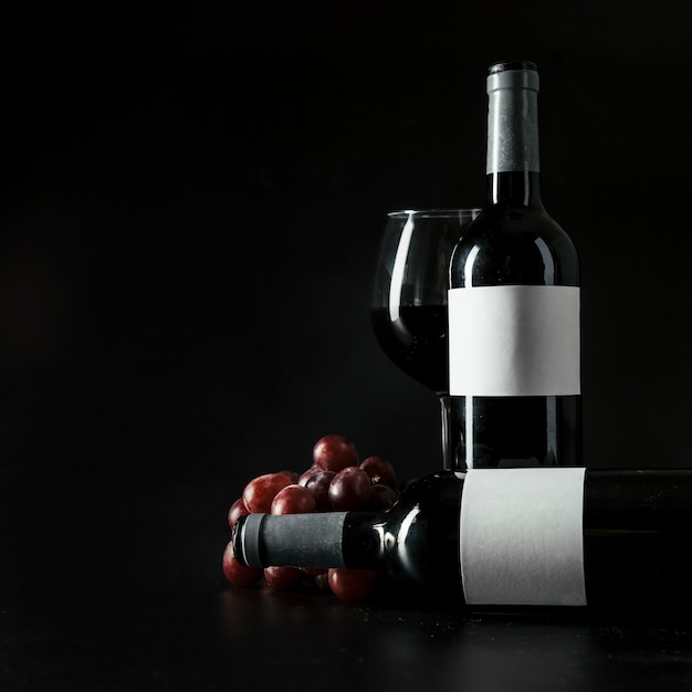 Bottles and wineglass near grape