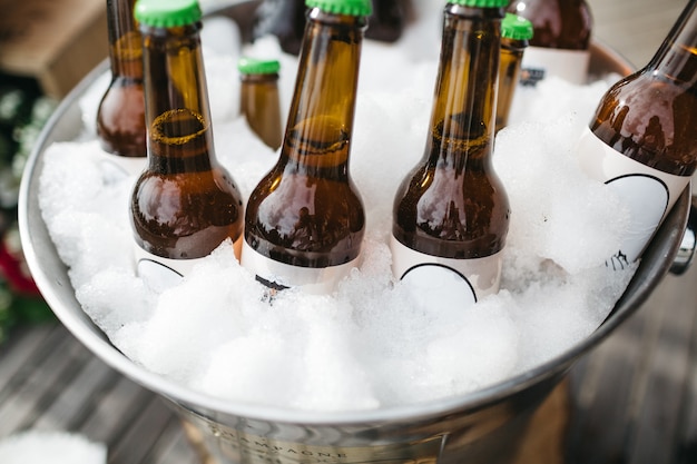 Bottles with beer are cooling in a pail with ice
