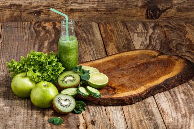 The bottles with fresh vegetable juices on wooden table