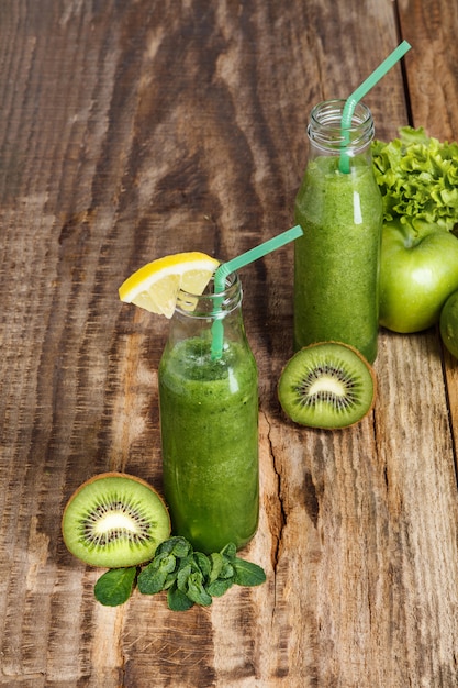 The bottles with fresh vegetable juices on wooden table