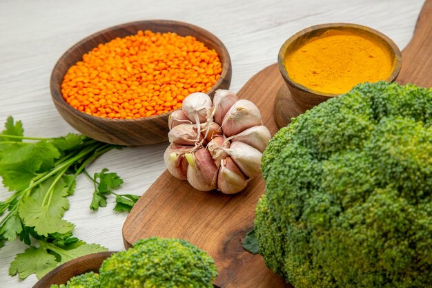 Bottom close view fresh broccoli garlic turmeric on cutting board parsley lentile bowl on grey table