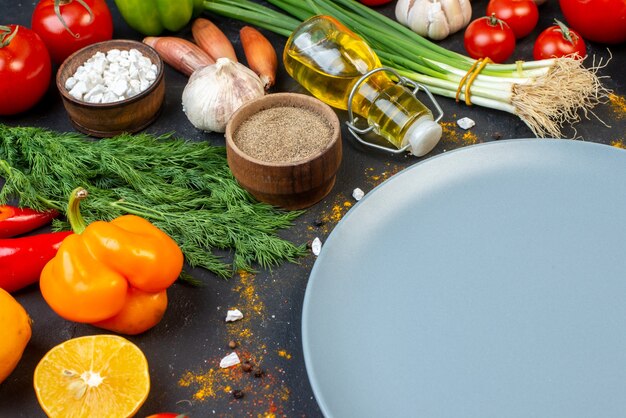 Bottom half view grey round platter fresh vegetables and other stuffs on table