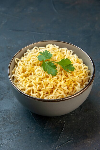 Bottom view asian ramen noodles with coriander in bowl on dark table