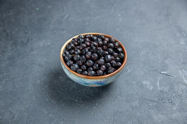 Bottom view black currant in bowl on dark surface free space