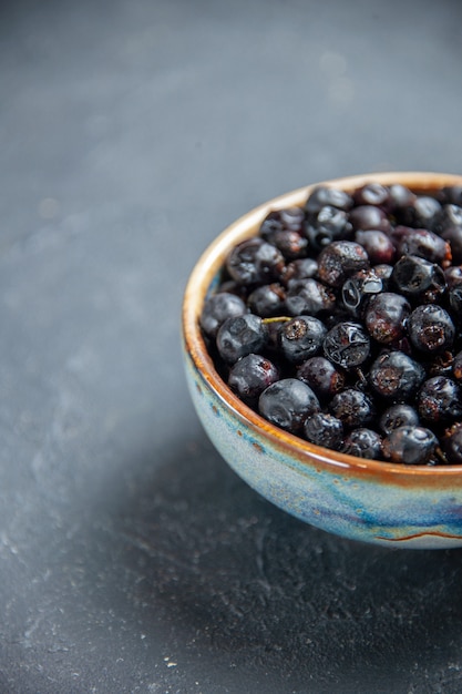 Bottom view black currant in bowl on dark surface