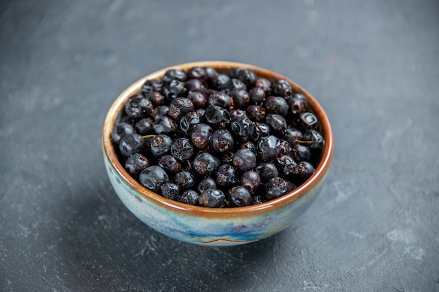 Bottom view black currant in bowl on dark surface