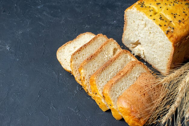 Bottom view bread slices wheat spikes on dark table with free space