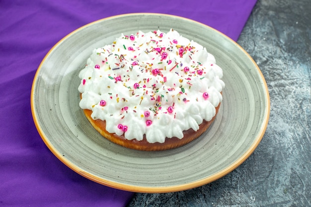 Torta vista dal basso con scialle crema viola sul tavolo grigio