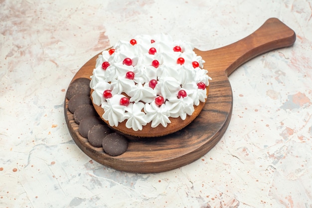 Bottom view cake with white pastry cream and chocolate on wooden cutting board on light grey surface